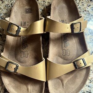 Comfortable two -strap Birkenstock sandals in gold leather. Virtually like new.